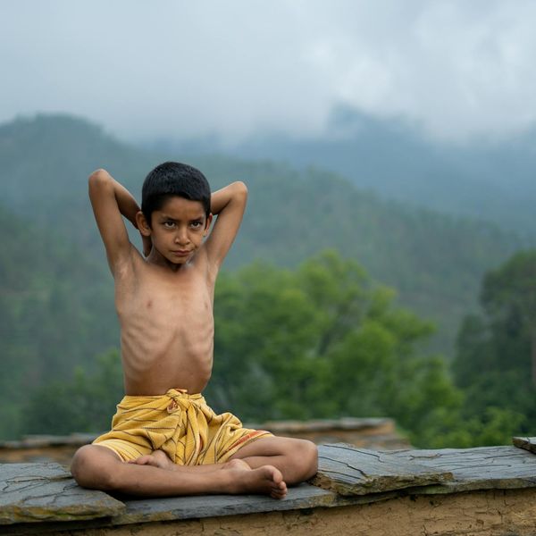 Person meditating peacefully outdoors with nature in the background.
